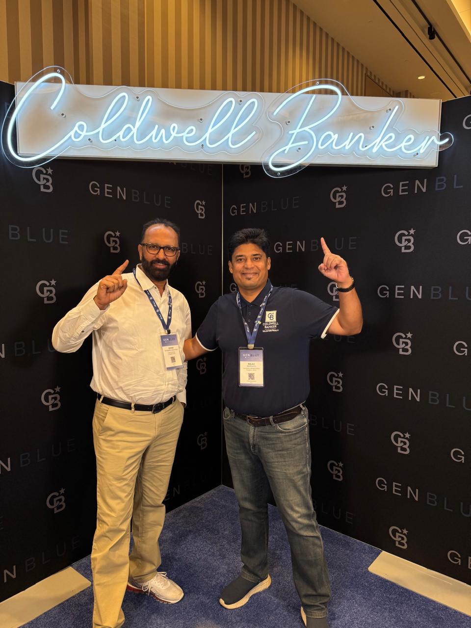 Govind Raj, Realtor, posing in front of a Coldwell Banker neon sign