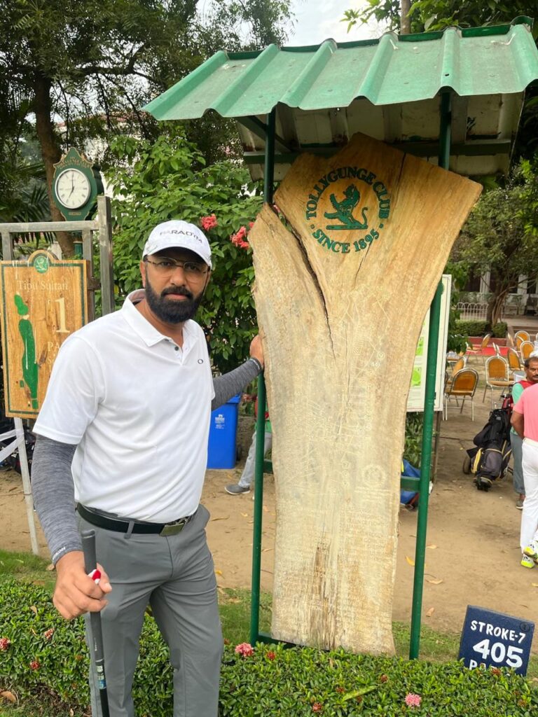Govind Raj beside a carved tree trunk at a golf course