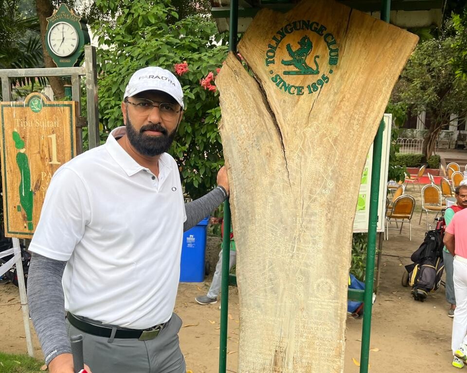 Govind Raj beside a carved tree trunk at a golf course